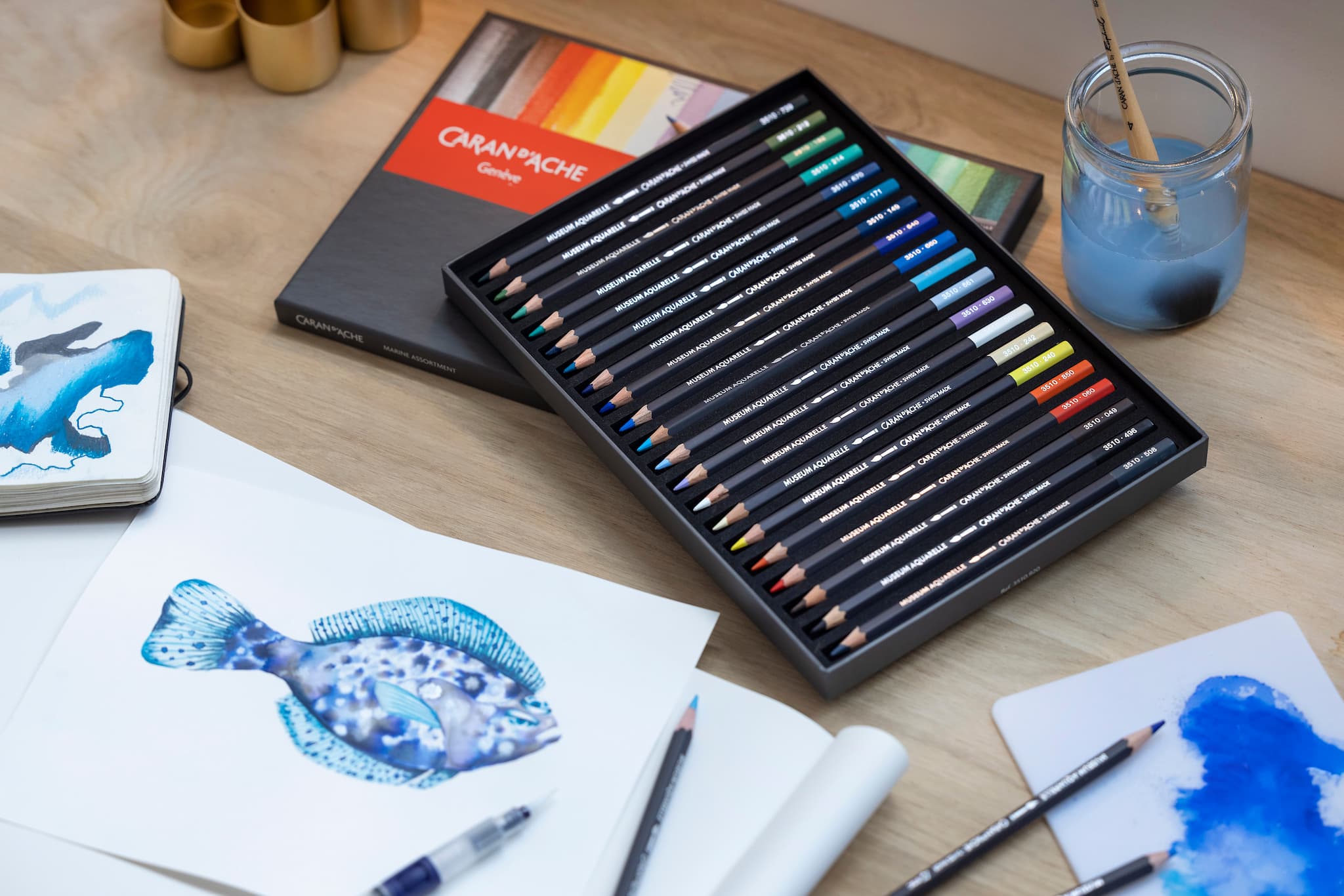 box of museum aquarelle pencils and blue drawings
